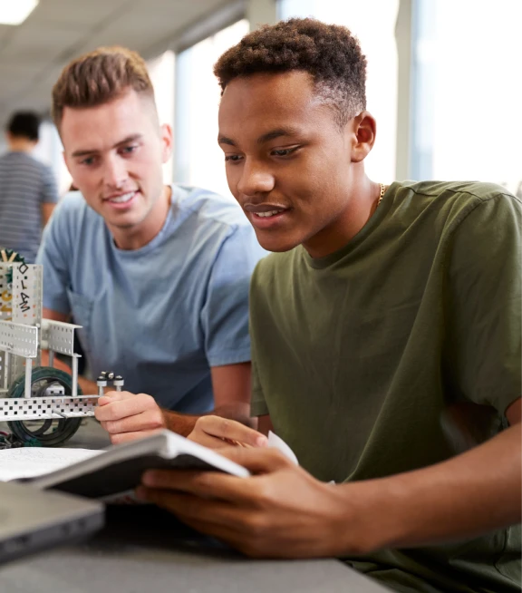 Two men work together in a classroom
