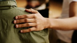 hand on the shoulder of a young adult