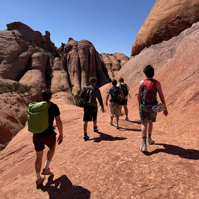 A group of young men hiking in red rock, southern Utah
