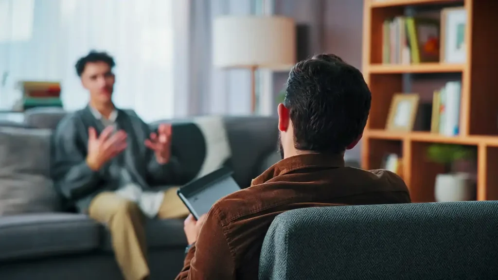 young man with a counselor for a therapy session in an office