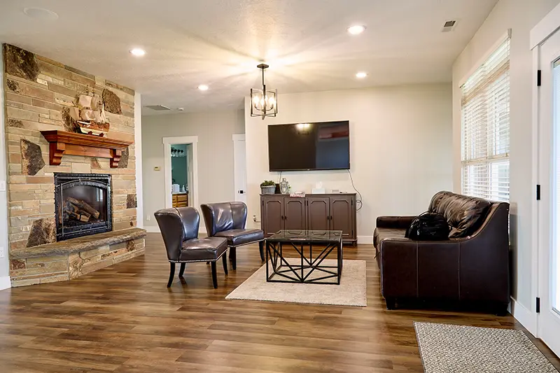 A comfortable living room with sofa, chairs, and a fireplace
